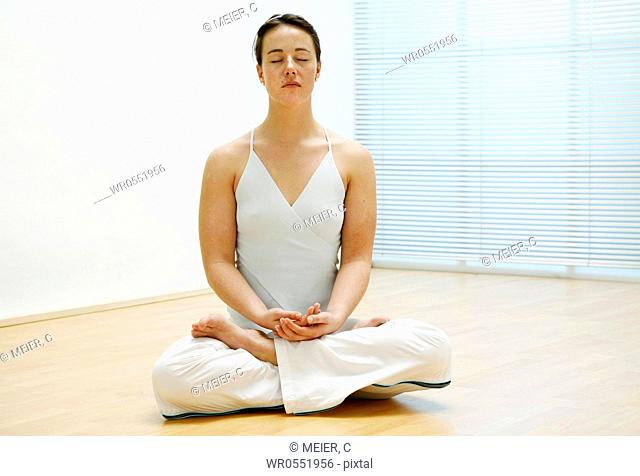 young woman sitting on the floor and is meditating