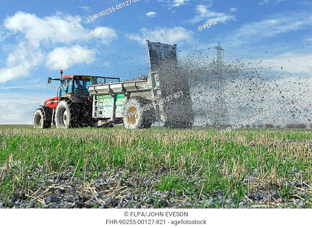Tractor with spreader, spreading paper waste, Thurnscoe, Yorkshire, England