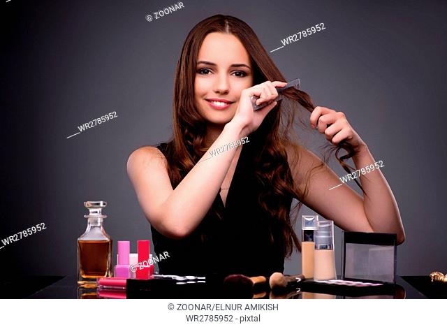 Beautiful woman applying make-up in fashion concept