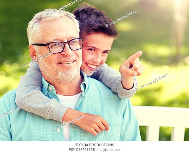 grandfather and boy pointing finger at summer park