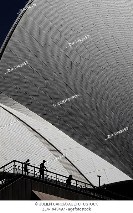 Silhouettes in front of Sydney Opera House and its wonderful curves. Australia, New South Wales, Sydney