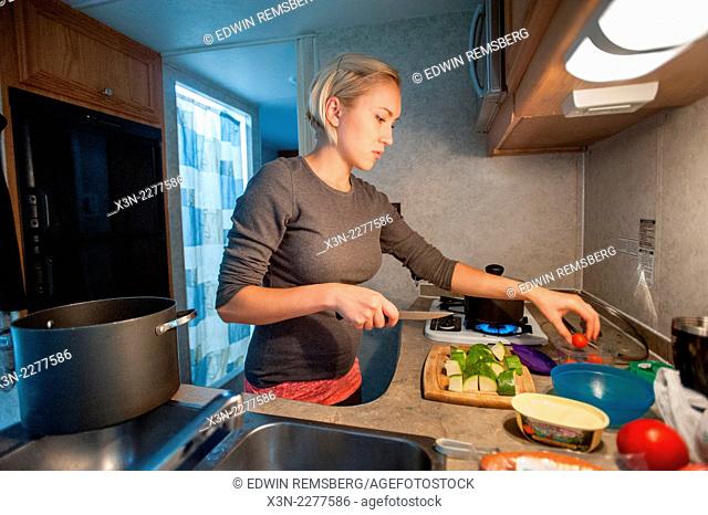 Woman cooking in RV kitchen