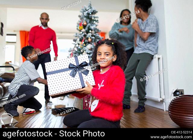 Portrait happy girl with Christmas gift in living room