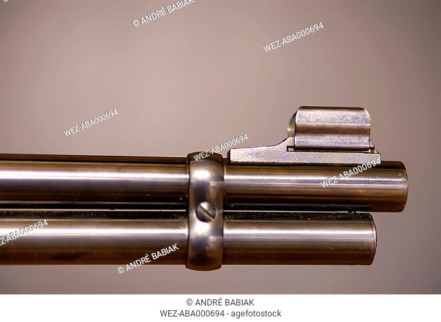 Gun barrel against brown background, close up