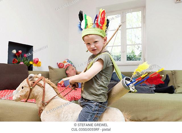 Boy in war bonnet playing with toys