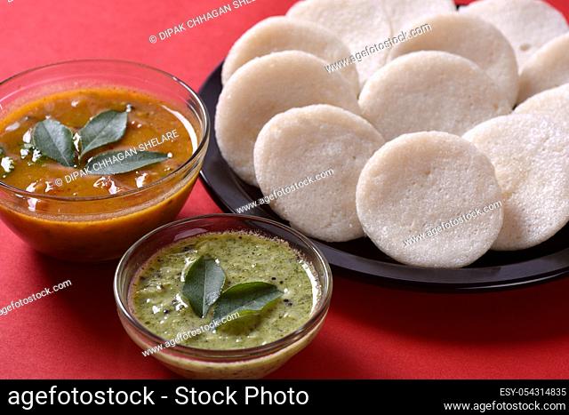 Idli with Sambar and coconut chutney on red background, Indian Dish : south Indian favourite food rava idli or semolina idly or rava idly