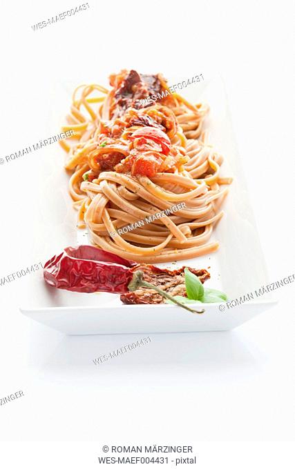 Linguini peperoncino rosso and pasta sauce in plate on white background