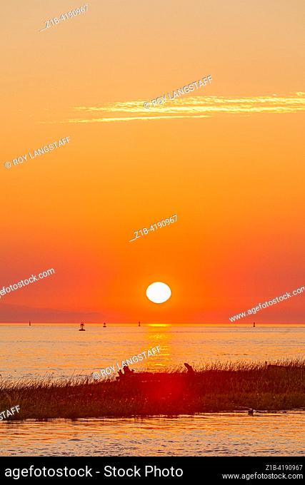 The sun setting over Vancouver Island as seen from Steveston in British Columbia Canada