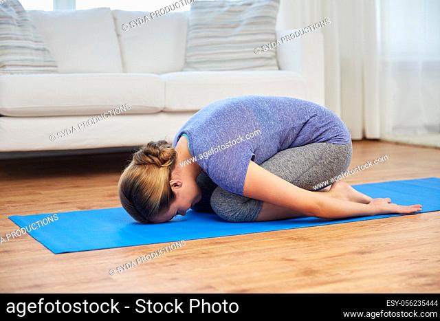 woman doing yoga child pose at home