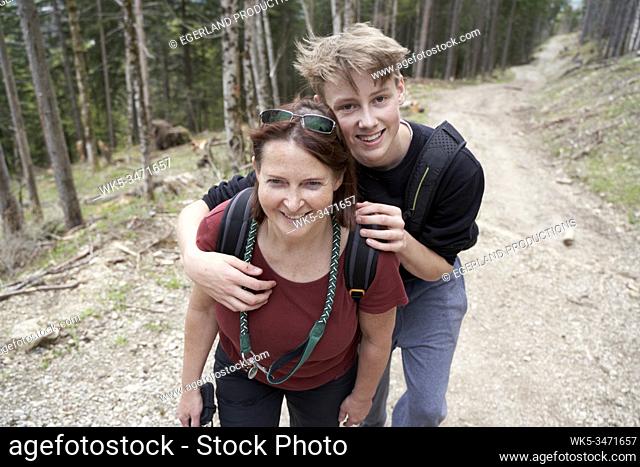Mature woman and teenager walking on a path in the forest. Bad Tölz, Upper bavaria, Germany