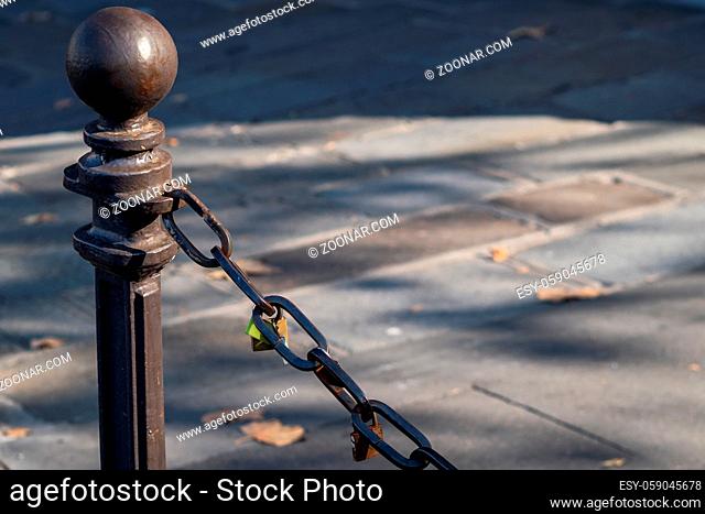 Padlocks attached to a chain in the streets of Paris