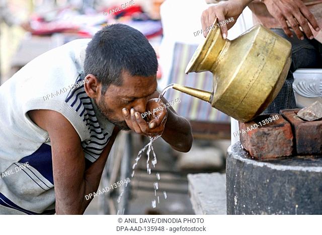 Man drinking water at pushkar fair ; Rajasthan ; India
