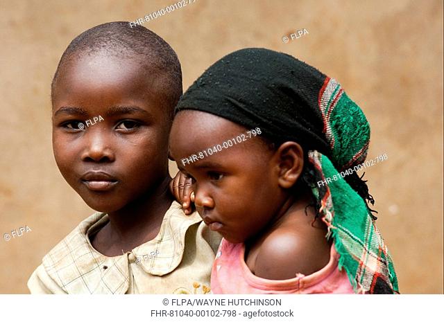Two sisters, one child carrying other, close-up of heads, Rwanda