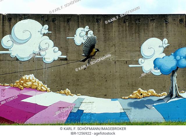 Bird of paradise flies over landscape, painted on concrete walls, surrealistic vision by the Karlsruhe graffiti artist Christian Kraemer aka Dome, Rheinpark