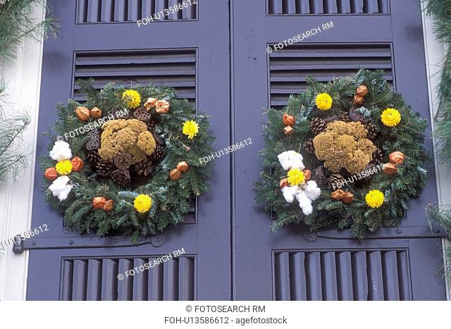 wreath, Colonial Williamsburg, Virginia, VA, Williamsburg, Two wreaths made of greens, dried flowers and fruit decorates the door of a home for Christmas in...