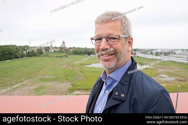 11 June 2020, Mecklenburg-Western Pomerania, Greifswald: Stefan Fassbinder (Green), Lord Mayor, is standing on the roof of the new municipal archive of the city...