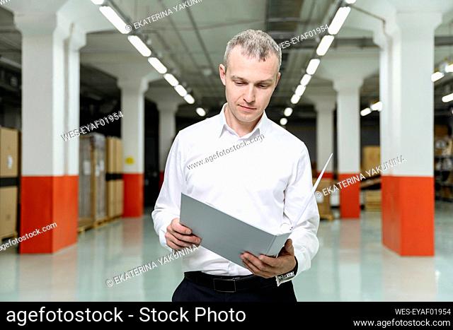 Businessman analyzing file in factory