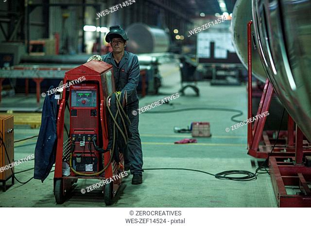 Worker with machine in factory