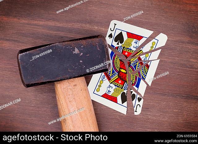 Hammer with a broken card, vintage look, jack of spades