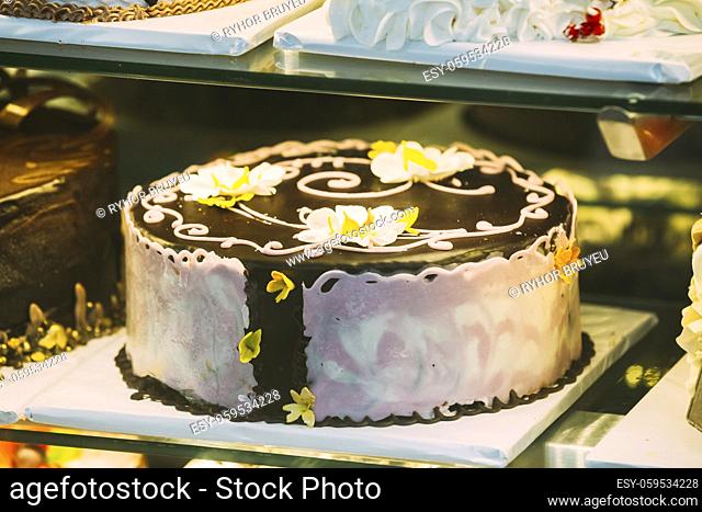 Fresh Sweet Cake With Different Chocolates In Pastry Shop Glass Display