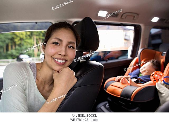 A mother and her young baby boy in a car