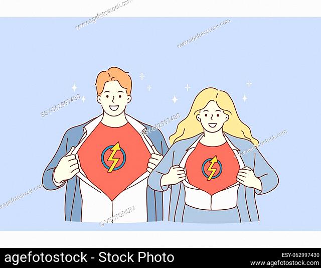 Business team and successful cooperation concept. Young man and woman business people partners standing together and showing superman sign on chests meaning...