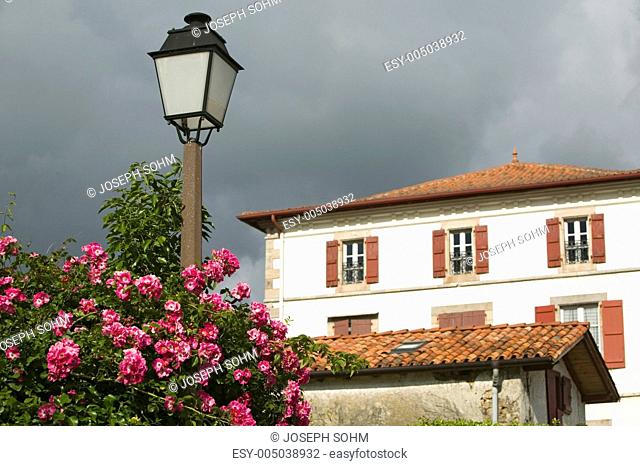 Summer flowers, lamp post and home in Sare, France in Basque Country on Spanish-French border, a hilltop 17th century village in the Labourd province
