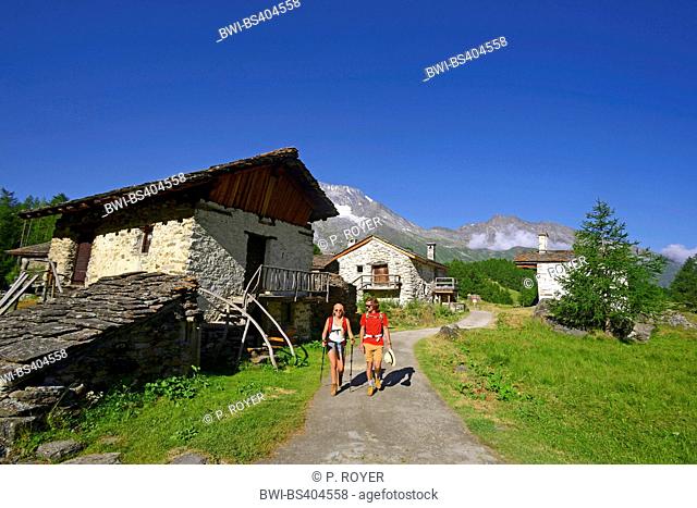 couple walking at a little mountain village in the French Alps, Le Monal , France, Savoie, Le Monal, Sainte-Foy-Tarentaise