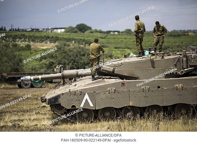 Israeli soldiers on top of a Merkava Mark IV tank that deployed along the border with Syria, in Golan Heights, Israel, 09 May 2018