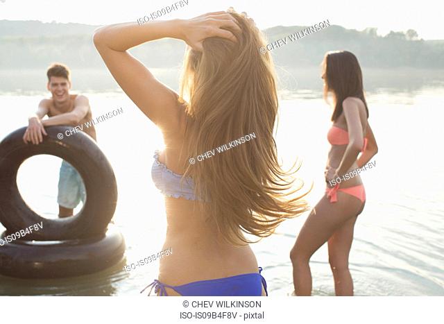 Friends having fun with inflatable ring in river