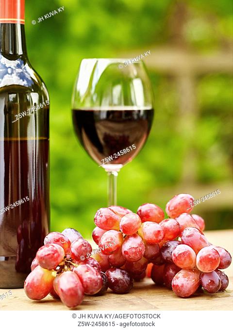 Red Wine, Glass and Grapes on the table - focus on grapes, vertical format