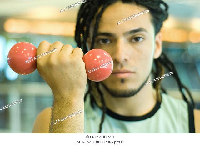 Young man holding up dumbbell