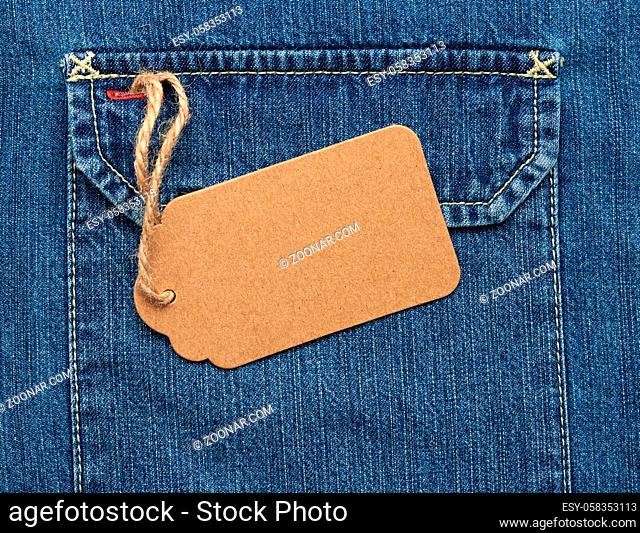 empty brown paper tag on a rope tied to blue jeans, full frame