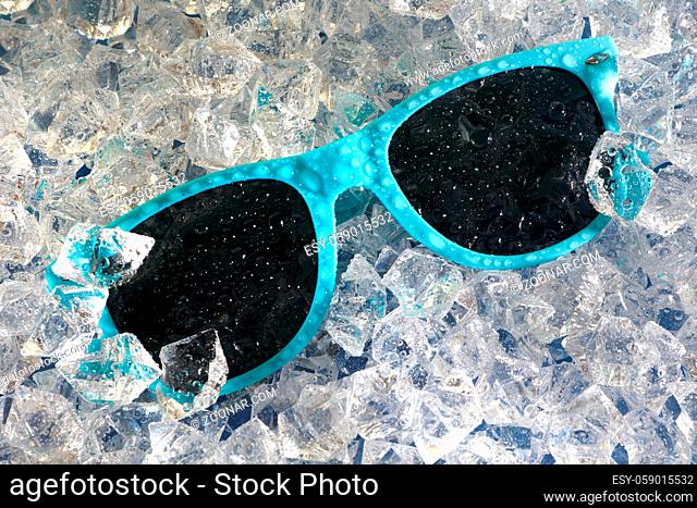 Water drops on blue sunglasses on a bed of ice