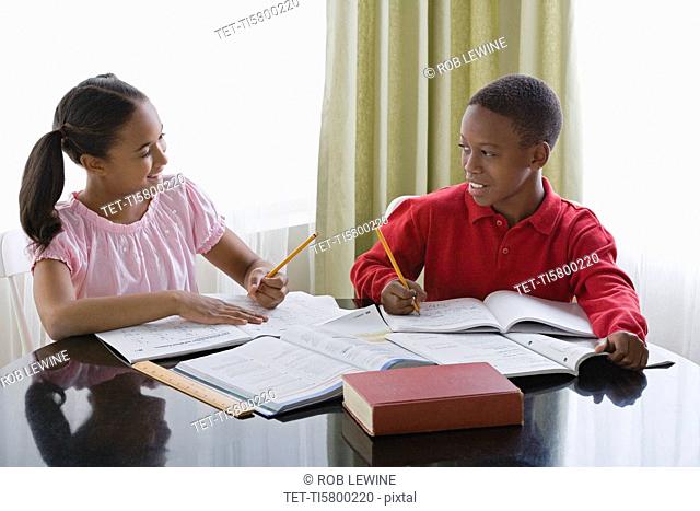 Brother and sister 10-13 doing homework