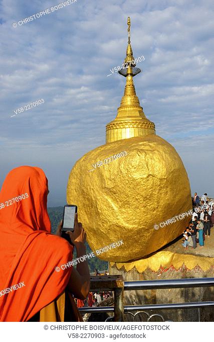 Myanmar, Kyaiktiyo, Buddhist monk taking a snap of the Golden Rock