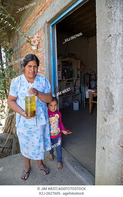 San Baltazar Chichicapam, Oaxaca, Mexico - Victoria Ramirez stands in front of her house with her granddaughter, Marely San Juan Hernández, 5