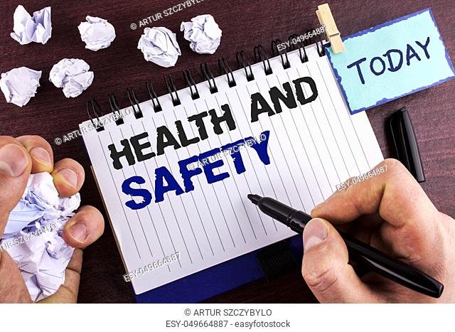 Text sign showing Health And Safety. Conceptual photo being in good condition harmless Workouts Healthy food written by Man Notepad holding Marker wooden...