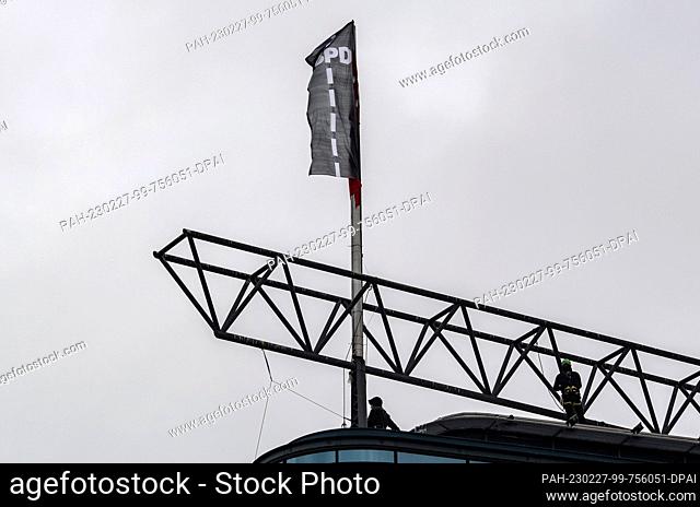 27 February 2023, Berlin: Activists from the environmental group Greenpeace have hoisted a new flag on the roof of the SPD federal party