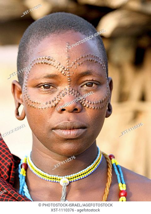 Africa, Tanzania, members of the Datoga tribe Woman in traditional dress, beads and earrings  Beauty scarring can be seen around the eyes, October 2008