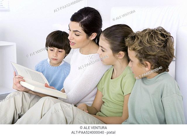 Woman reading story to her children