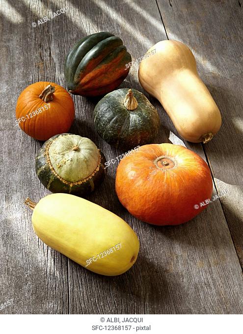 Various pumpkins on a wooden surface