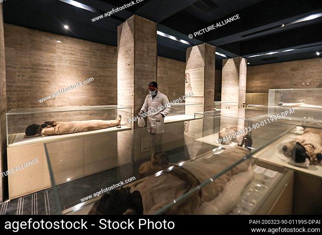 23 March 2020, Egypt, Cairo: A worker sprays disinfectant around mummies, on a display at the Egyptian museum as a preventive measure against the spread of...