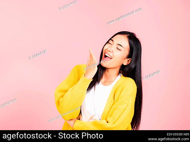 Happy Asian portrait beautiful cute young woman standing winning and surprised excited screaming laugh hand cover mouth, studio shot isolated pink background