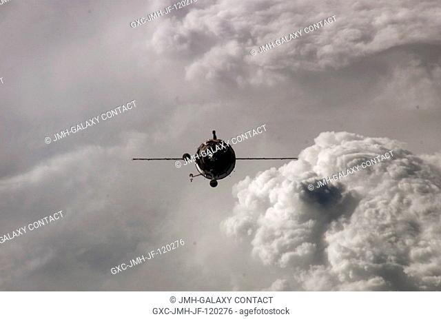Backdropped by a cloud-covered Earth, the Soyuz 14 (TMA-10) spacecraft approaches the International Space Station. Onboard the spacecraft are cosmonauts Fyodor...