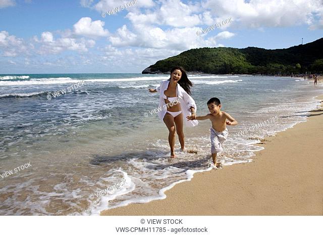 Mother And Son Running And Playing On The Beach, America