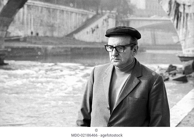 Italian writer Vasco Pratolini walking on the Tiber Island. Rome, 1969
