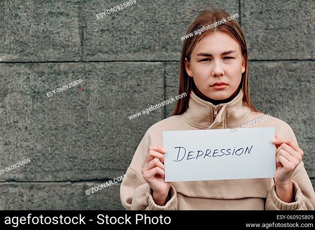 Girl holds in hand sheet of paper with word Depression