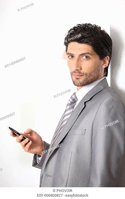 Serious businessman holding a mobile phone
