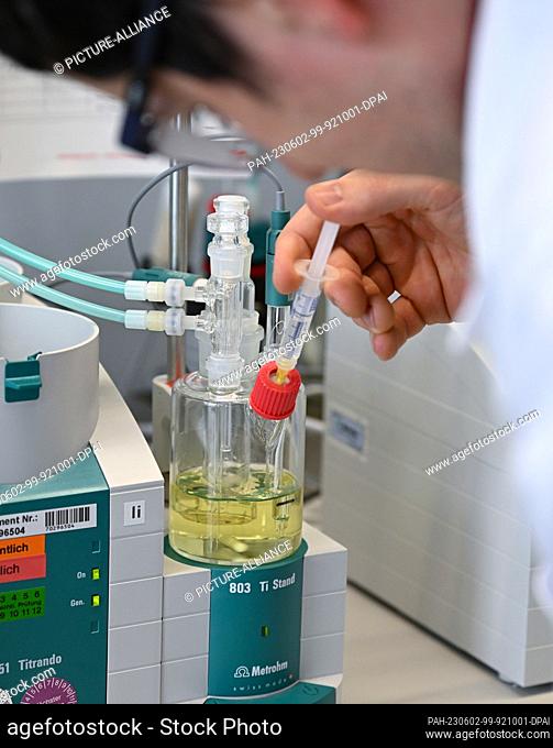PRODUCTION - 23 May 2023, Hesse, Darmstadt: Chemical laboratory technician Stefan Gemessy determines the water content of a high-purity solvent for laboratory...